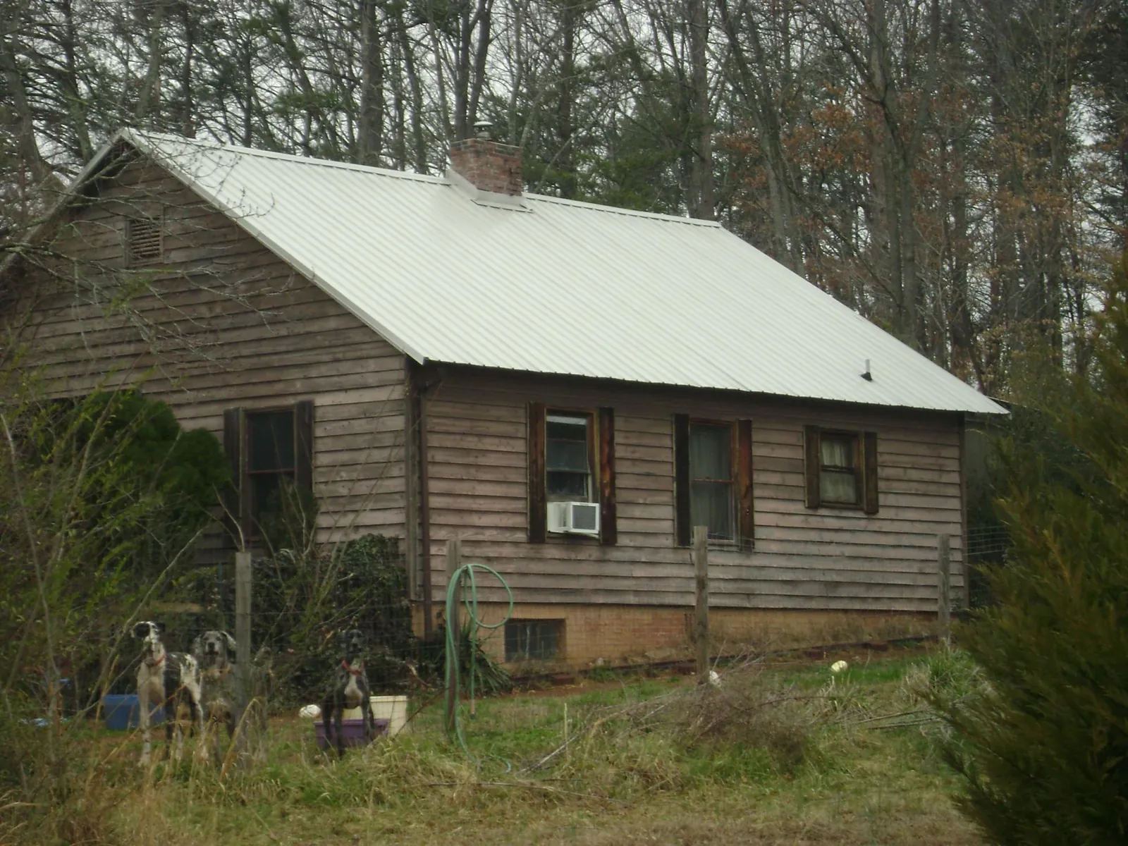 White metal roof on an old wood sided farmhouse, from a Asphalt Shingle Roof Repair job in Iowa City