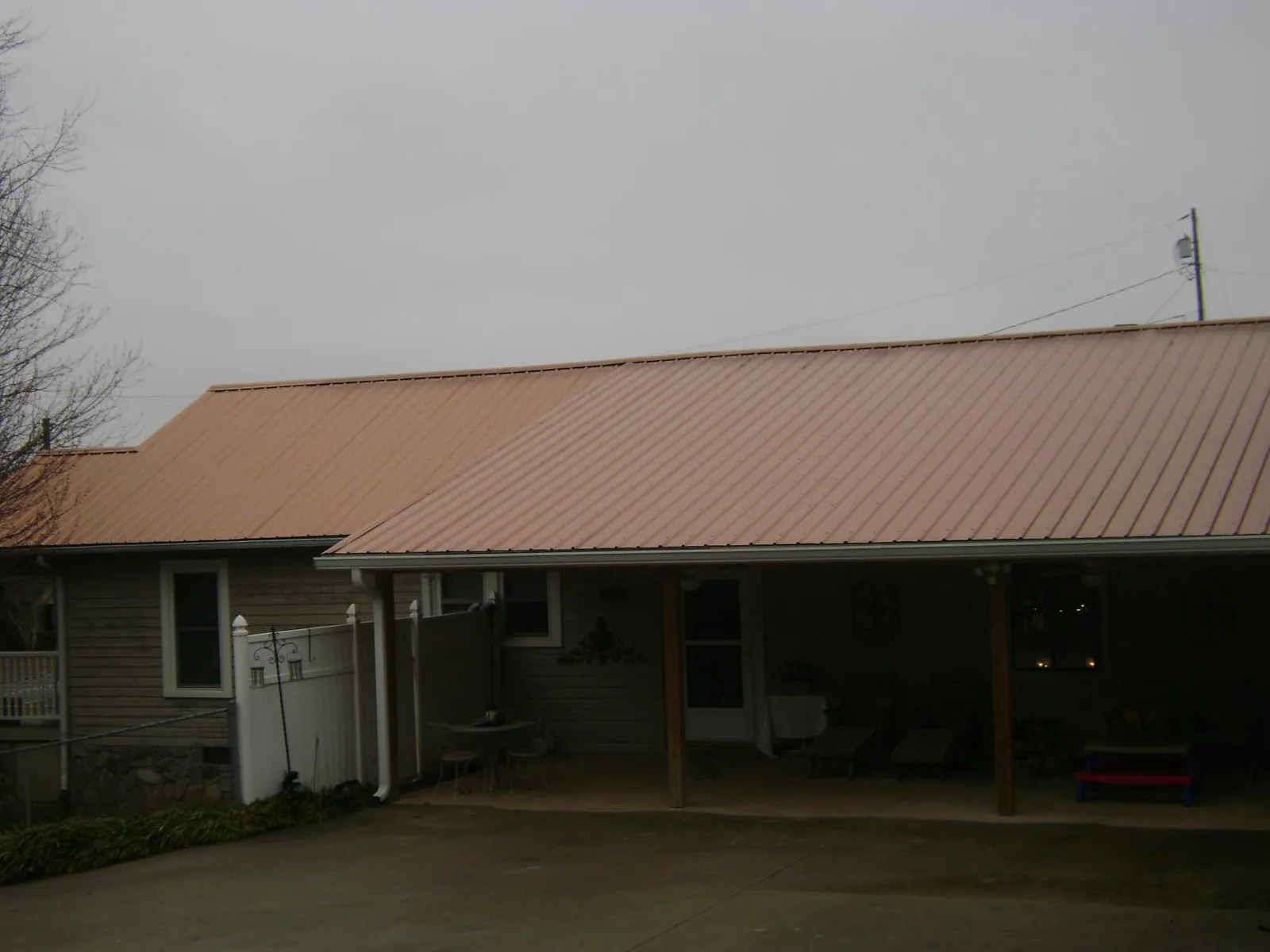 Copper toned metal roof over a wide covered patio in Iowa City